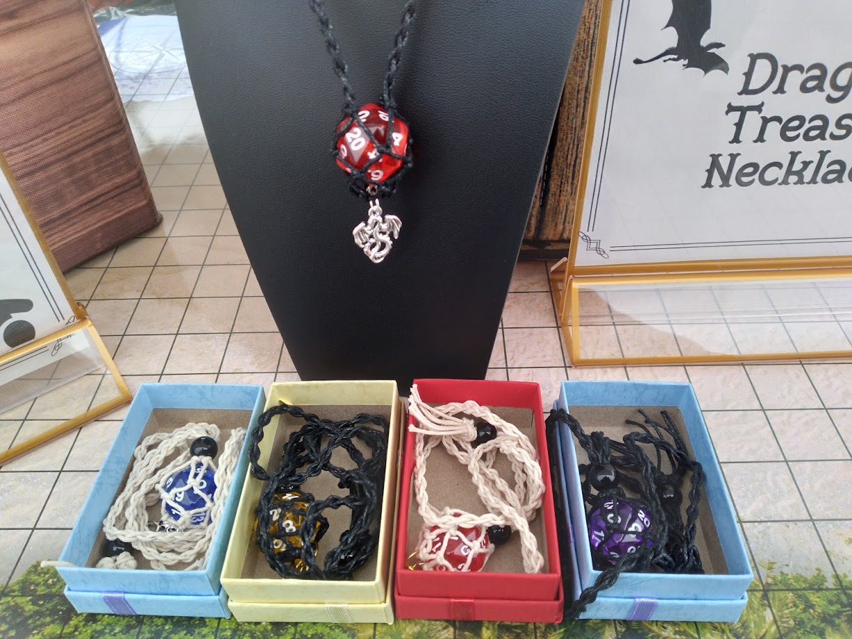 A set of necklaces; woven cords attached to d20 dice in different colors.