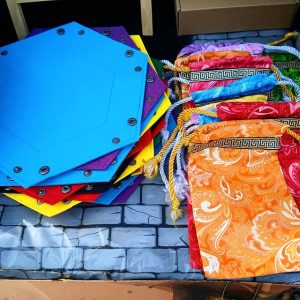 A set of colorful dice rolling trays and pouches on a table