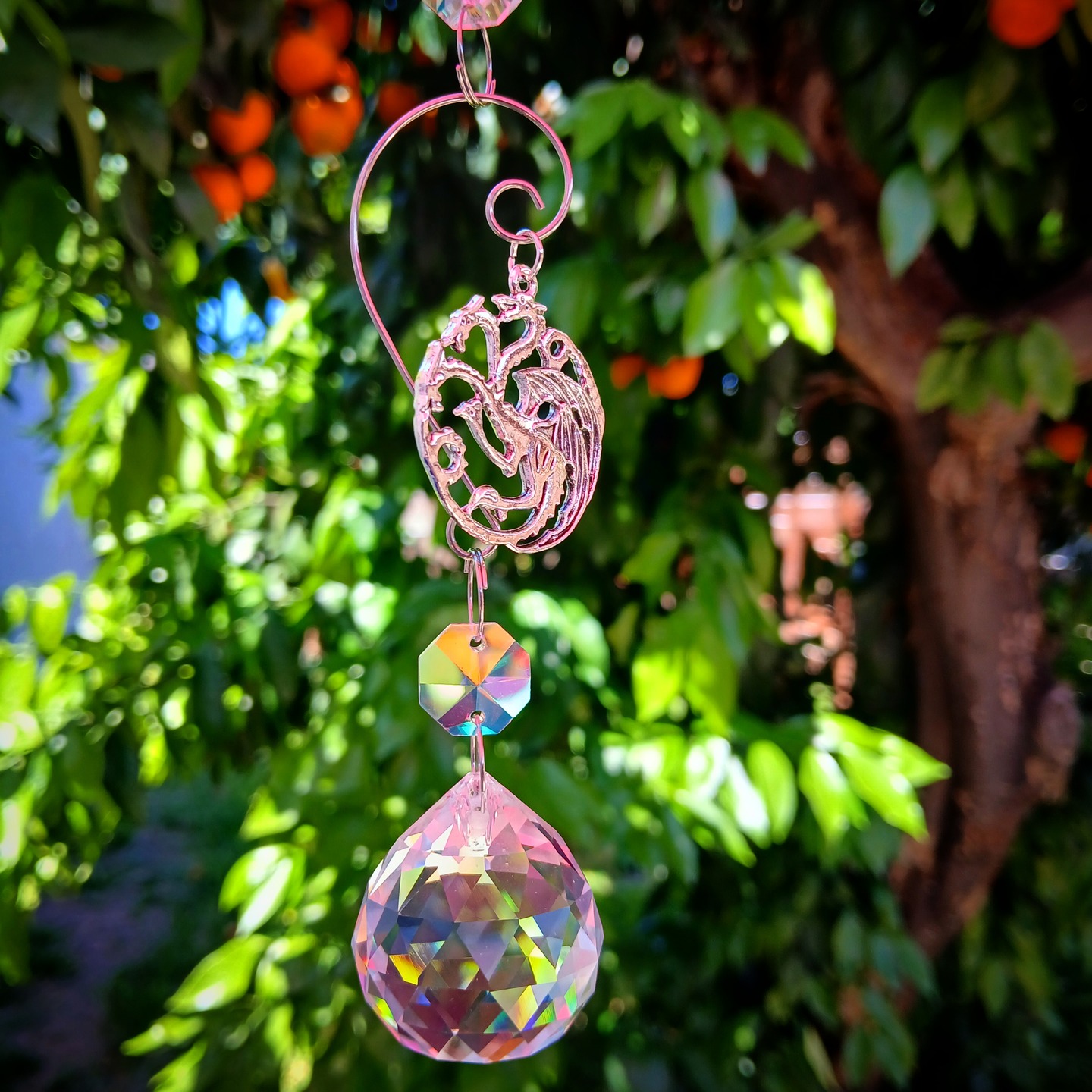 A sun catcher crystal ball with a three headed dragon charm